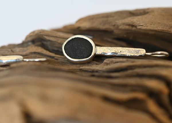Handmade silver earrings with black seashore pebble stone and rough surface