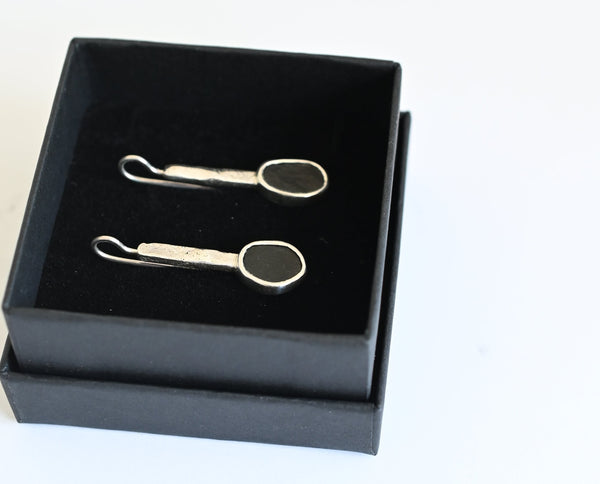 Handmade silver earrings with black seashore pebble stone and rough surface
