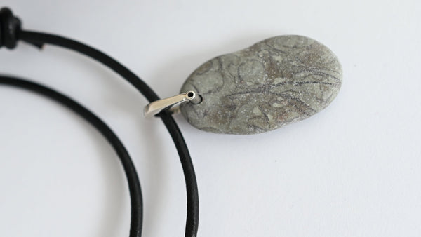 Necklace with a stone pendant on a black leather cord with sliding knots