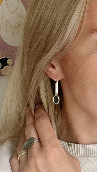 Handmade silver earrings with black seashore pebble stone and rough surface
