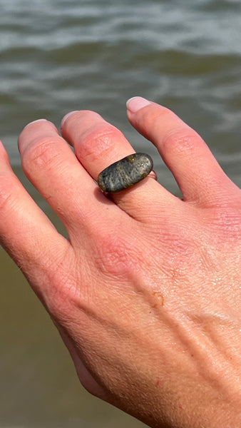 Hand with natural black seashore pebble stone