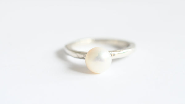 Elegant white pearl ring with a silver band, perfect for both everyday wear and special occasions.