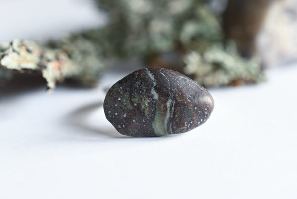 Handmade silver ring with a beach oval-shaped pebble in purple and green colours