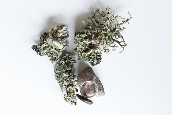 Handmade silver ring with a beach oval-shaped pebble in purple and green colours