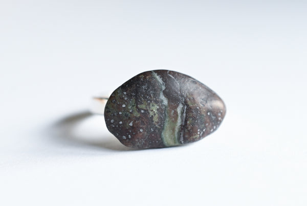 Handmade silver ring with a beach oval-shaped pebble in purple and green colours