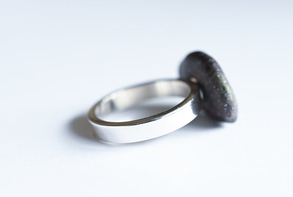 Handmade silver ring with a beach oval-shaped pebble in purple and green colours