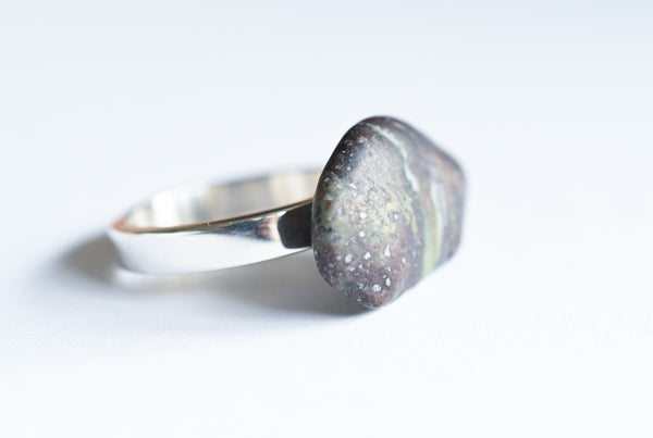 Handmade silver ring with a beach oval-shaped pebble in purple and green colours