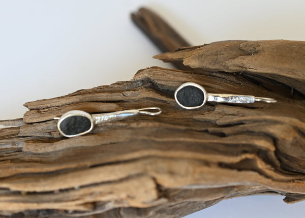 Handmade silver earrings with black seashore pebble stone and rough surface