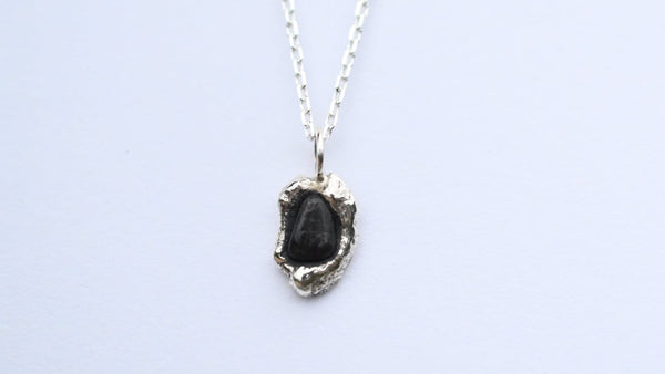 Organic shaped silver sterling pendants with black seashore pebble seaside stone on silver chain