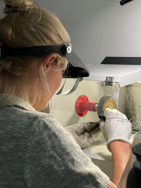 woman jeweller polishing silver and gold jewellery