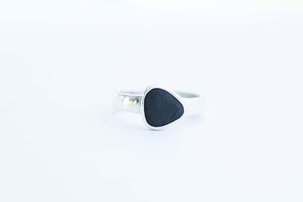 Silver ring with a black triangle seashore stone. Pebbles.