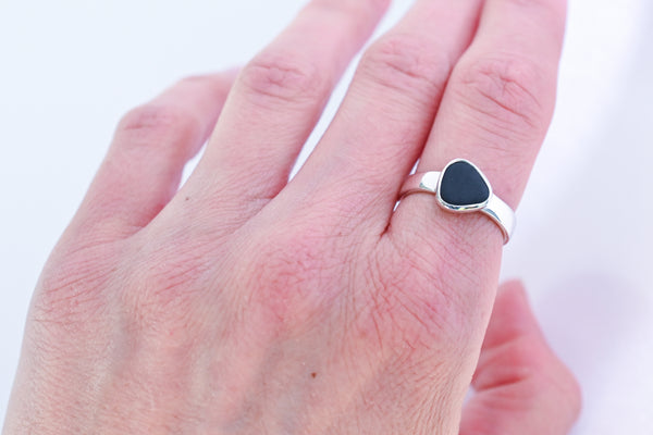 Silver ring with a black triangle seashore stone. Pebbles.