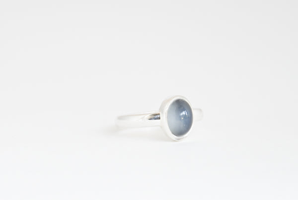 Silver ring with a blue moonstone on a white background