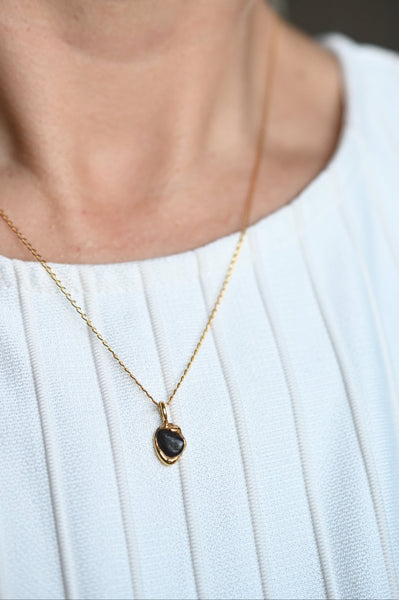 24k vermeil chain that holds golden pendant with black seashore pebble. Jewellery for everyday and special occasions 