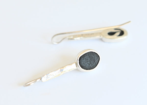 Handmade silver earrings with black seashore pebble stone and rough surface